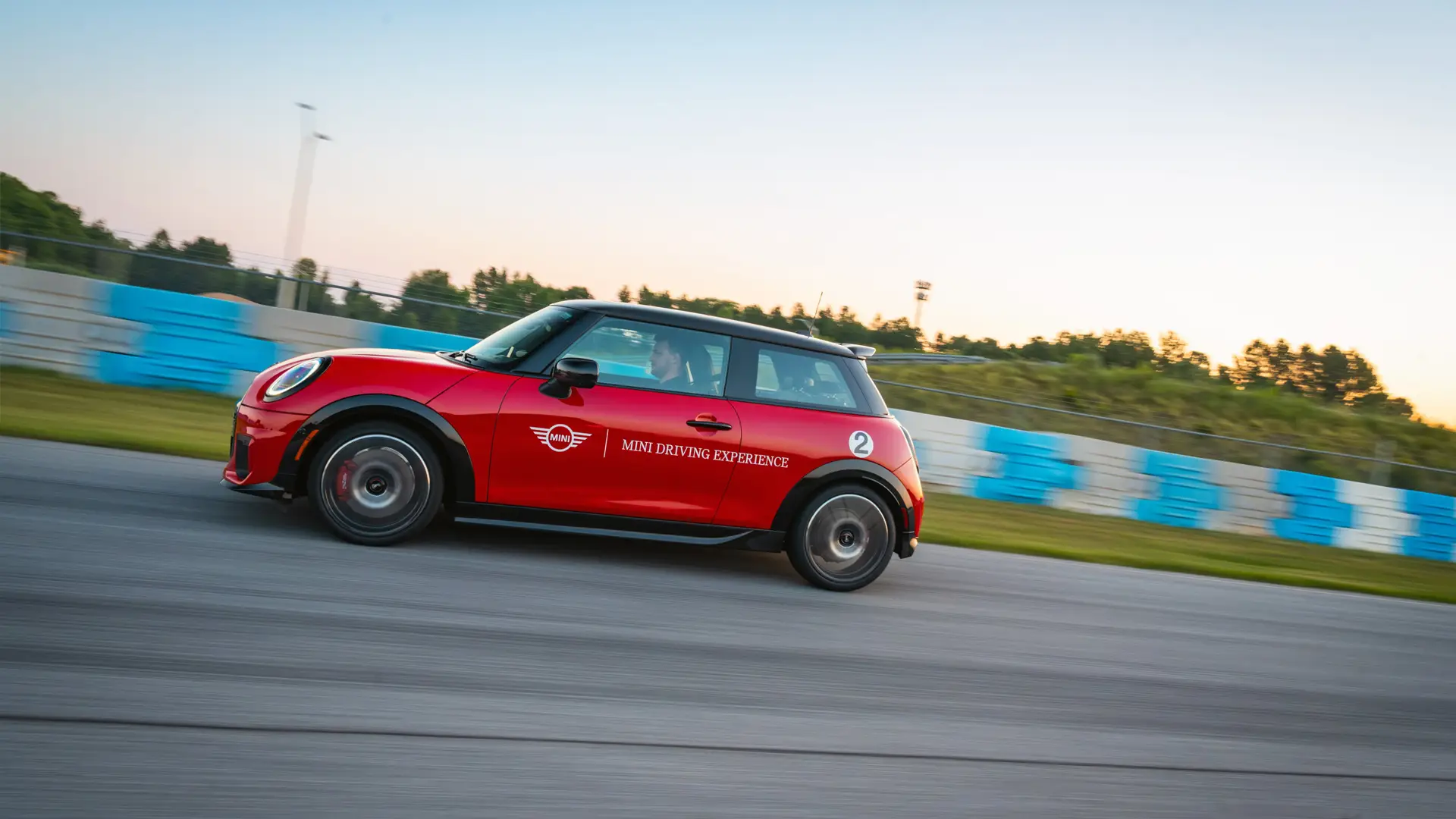 Red MINI Driving Experience car at speed along the main straight